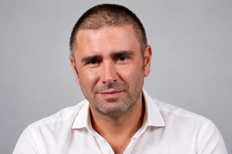 Ritratto editoriale neutrale di Alessandro Di Battista generato con IA su sfondo grigio; non è una fotografia documentaria.