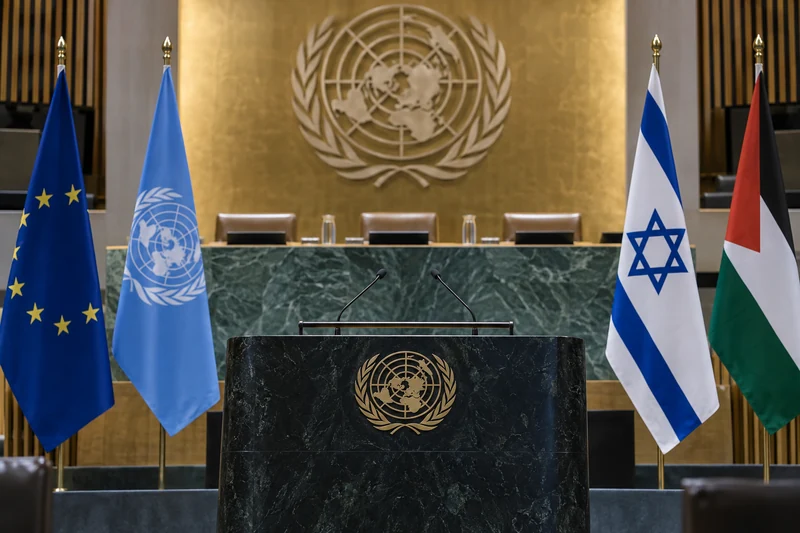 Illustrazione editoriale IA neutrale di una sala diplomatica ONU con bandiere europea, ONU, israeliana e palestinese; scena non documentaria.