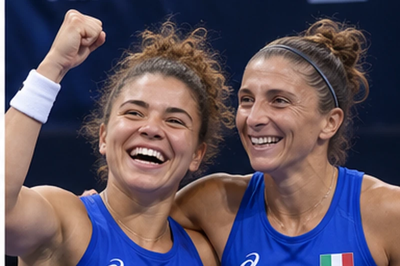 Foto d'archivio di Jasmine Paolini e Sara Errani che esultano abbracciate in divisa azzurra, con il logo della Billie Jean King Cup sullo sfondo.