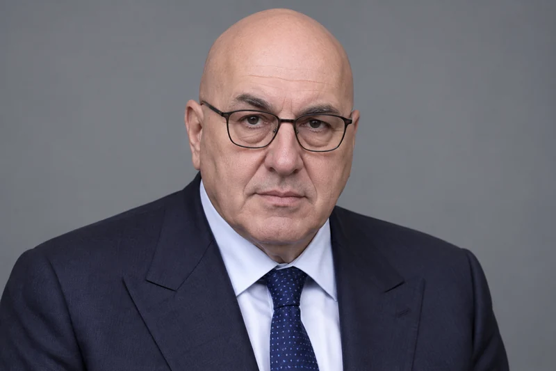 Ritratto editoriale neutrale di Guido Crosetto, somiglianza sintetica non documentaria.