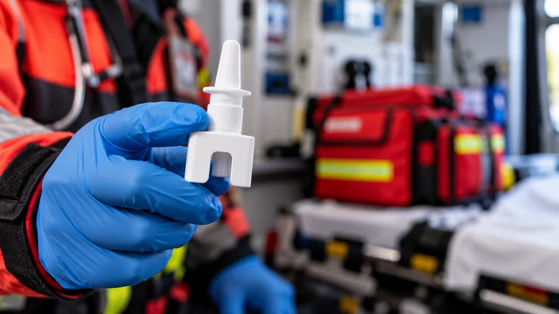 Dispositivo spray nasale in mano a un soccorritore, scena illustrativa IA