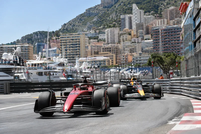 Scena editoriale contestuale generata con IA: due monoposto di Formula 1 affrontano una curva del circuito cittadino di Monaco; non rappresenta una gara specifica.