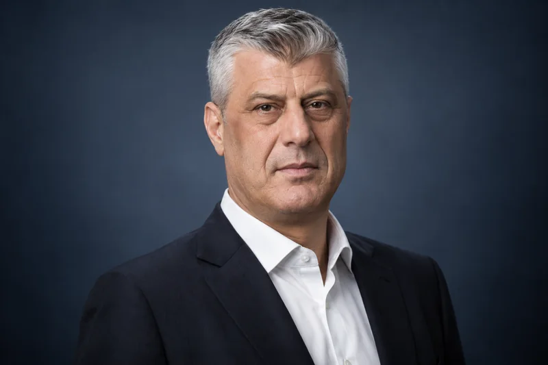 Ritratto editoriale neutrale generato con IA di Hashim Thaçi su sfondo blu scuro, realizzato per una notizia sensibile e non documentario.