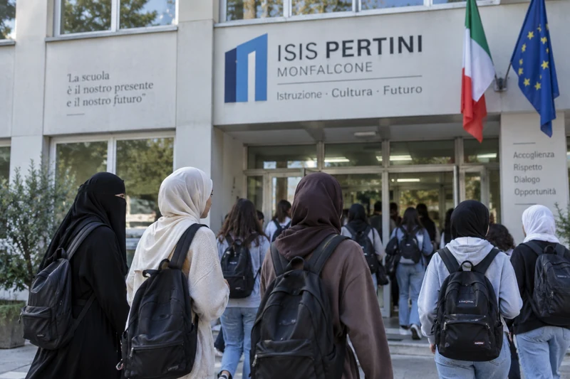 Illustrazione editoriale di un gruppo di studentesse davanti all'ingresso di un istituto scolastico italiano, alcune con il capo coperto da velo, altre a viso scoperto.
