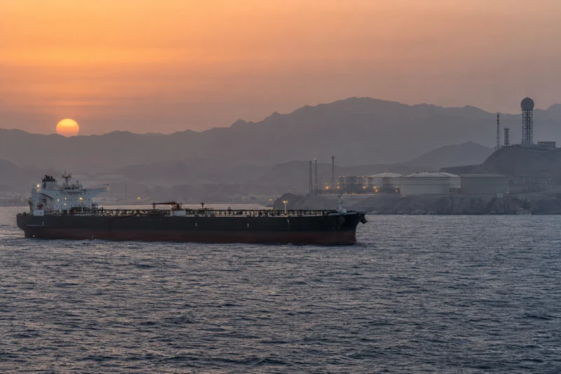 Scena editoriale sensibile ultrarealistica e non documentaria nel Mar Rosso, con petroliera al largo e infrastrutture energetiche saudite sulla costa, senza attacchi o vittime visibili.