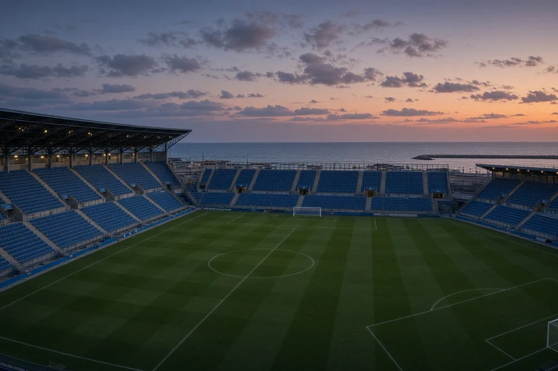 Illustrazione editoriale generata con IA: stadio Adriatico di Pescara al crepuscolo, campo vuoto; non è una fotografia documentaria.