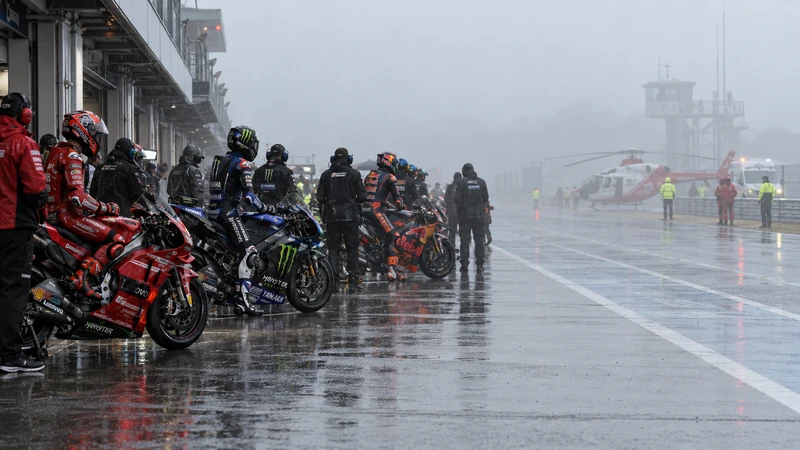MotoGP ferma nella pit lane di Phillip Island per nebbia e pioggia, illustrazione editoriale generata con IA