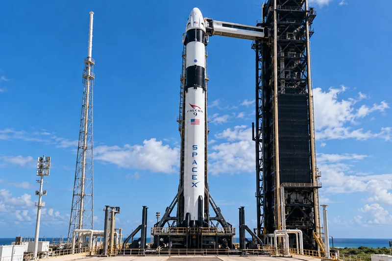 Illustrazione editoriale IA del razzo Falcon 9 con Crew Dragon sulla rampa di lancio a Cape Canaveral; scena non documentaria.
