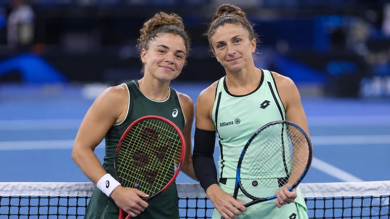 Scena editoriale IA con Jasmine Paolini e Sara Errani riconoscibili, in volto su un campo di tennis; non è una fotografia delle vittorie a Wuhan.