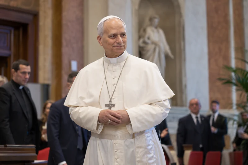 Scena editoriale contestuale ordinaria generata con IA: Papa Leone XIV riconoscibile in un interno istituzionale romano, con espressione serena; somiglianza sintetica, non è una fotografia documentaria.