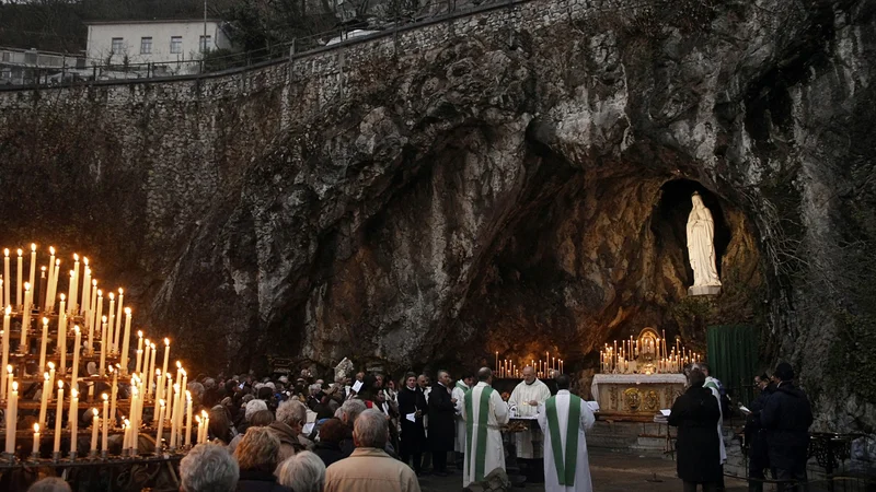 Grotta di Lourdes con candele e pellegrini; illustrazione editoriale IA non documentaria.
