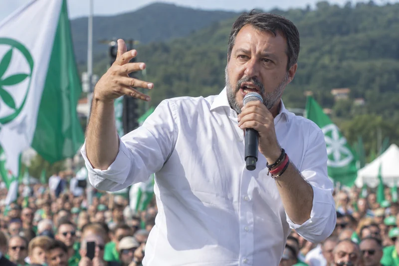 Scena editoriale contestuale ordinaria generata con IA: Matteo Salvini riconoscibile parla a un raduno della Lega a Pontida; somiglianza sintetica, non è una fotografia documentaria.