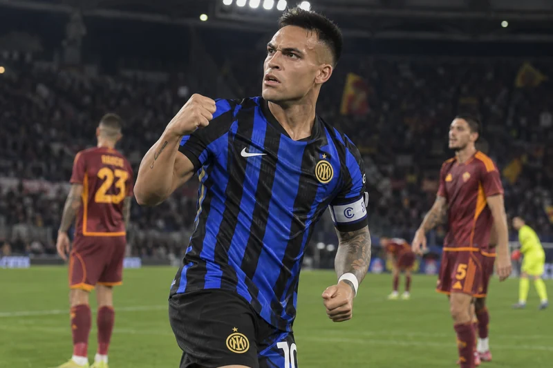 Scena editoriale contestuale ordinaria generata con IA: Lautaro Martínez riconoscibile celebra in maglia nerazzurra con calciatori della Roma sullo sfondo; somiglianza sintetica, non è una fotografia documentaria.