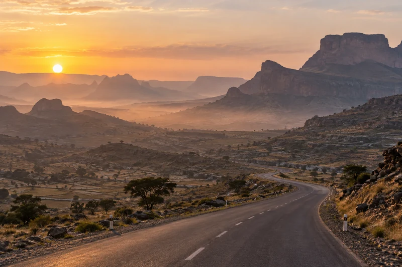 Illustrazione editoriale IA sobria degli altopiani del Tigray con una strada vuota; scena non documentaria.