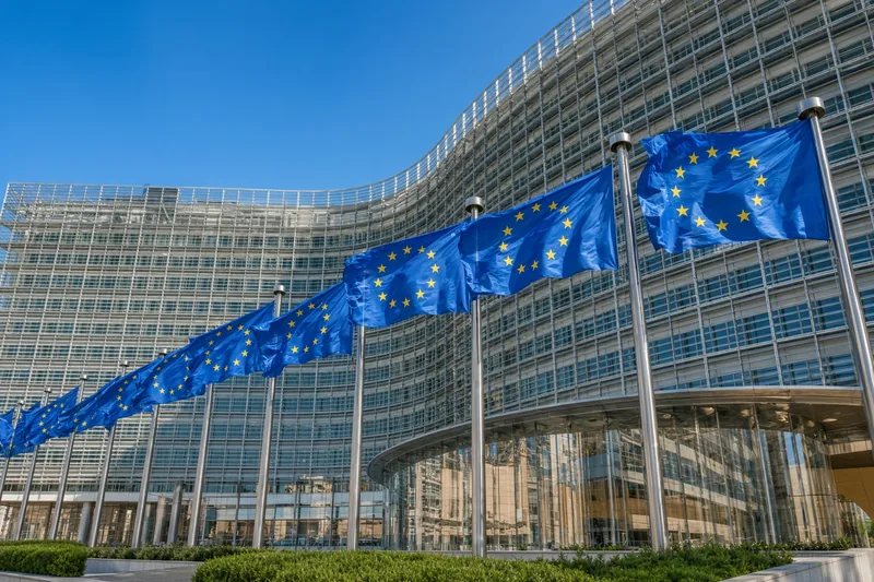Illustrazione editoriale IA della sede della Commissione europea a Bruxelles con bandiere UE: scena non documentaria.