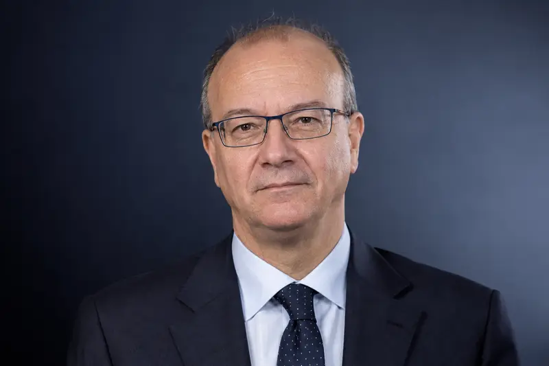 Ritratto editoriale neutrale isolato generato con IA di Giuseppe Valditara, ministro dell'Istruzione, su sfondo di studio; non documentario.
