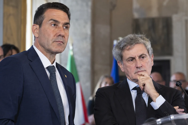 Foto d'archivio di Roberto Vannacci al microfono con Gianni Alemanno accanto durante un momento del Forum di Orvieto, in una sala con bandiera italiana ed europea.