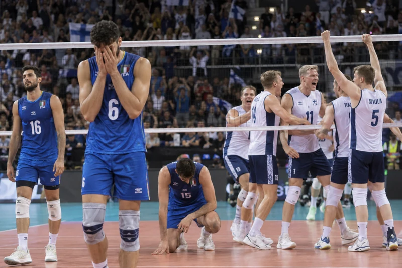 Foto d'archivio dei giocatori della nazionale italiana di volley maschile delusi in campo mentre i giocatori della Finlandia esultano dopo la vittoria agli Europei.