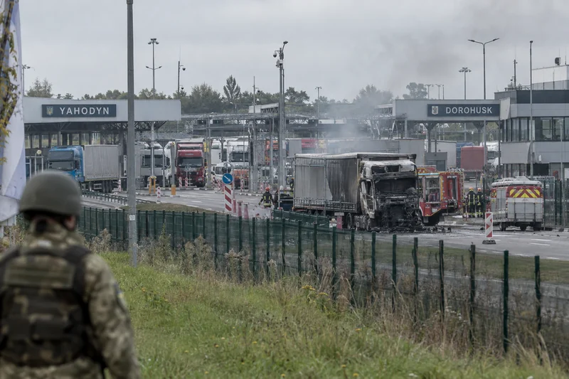 Scena editoriale sensibile generata con IA di un camion danneggiato vicino al valico Yahodyn–Dorohusk, senza vittime visibili
